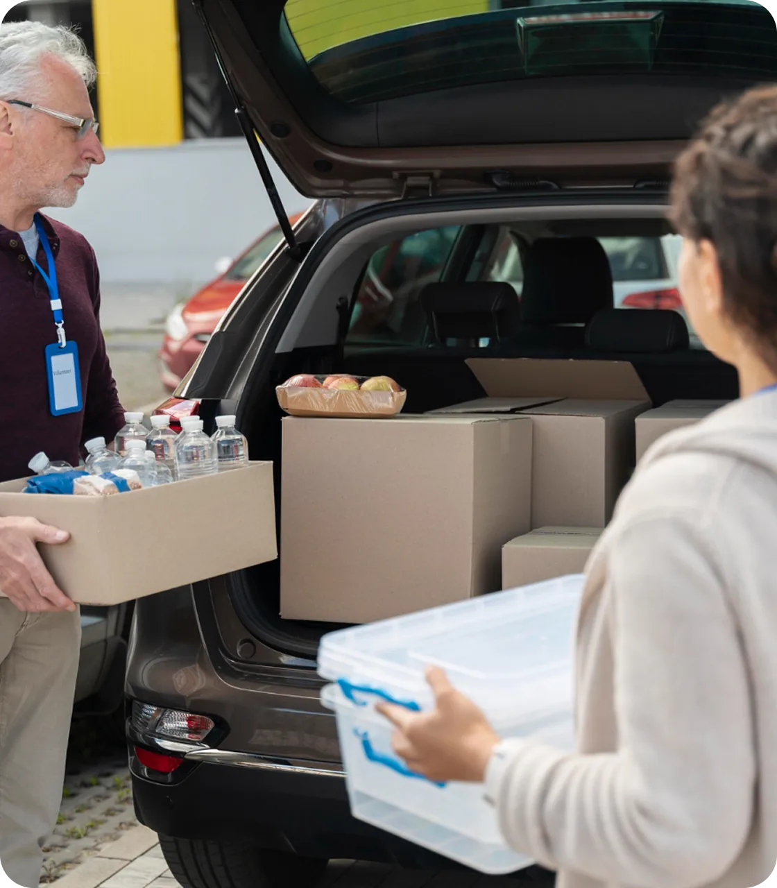 Волонтери завантажують допомогу в багажник автомобіля
