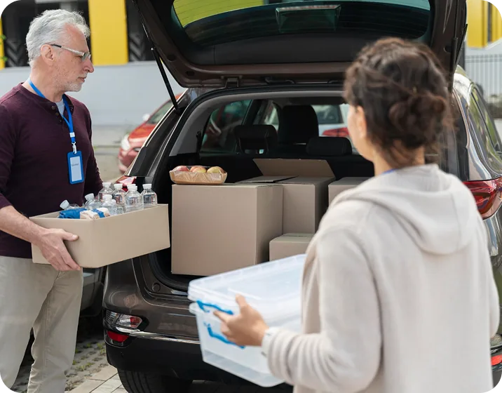 Волонтери завантажують допомогу в багажник автомобіля